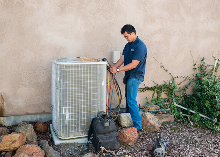HVAC repair contractor working on an AC unit